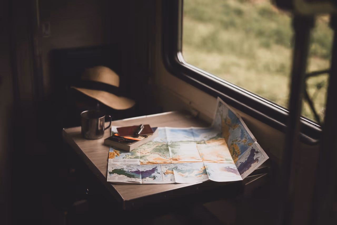 A paper road map spread on a table inside a camper van